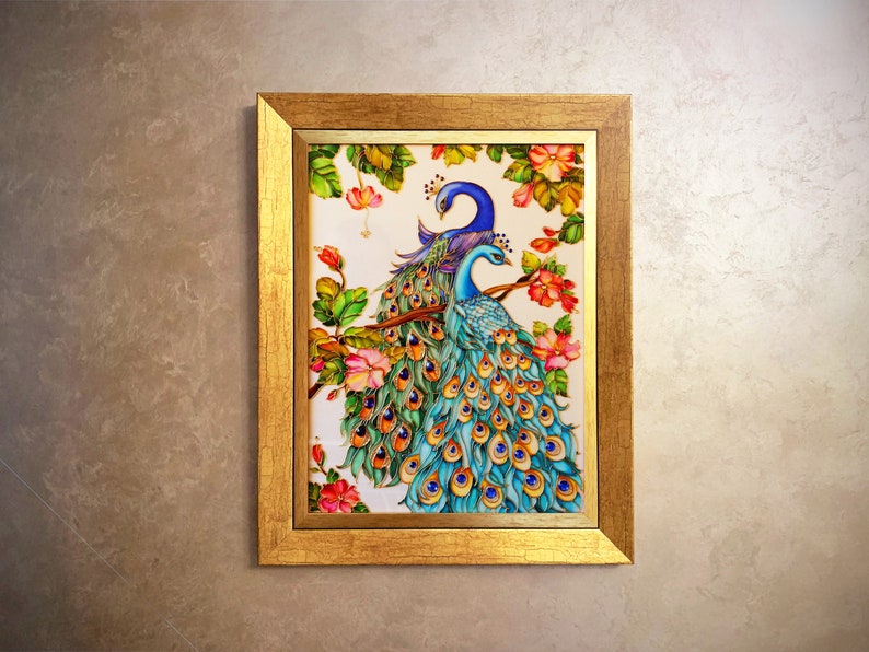 May include: A framed artwork featuring two peacocks perched on a branch with colorful plumage. The painting showcases vibrant blues, greens, and oranges, set against a white background with floral accents. The frame is gold.