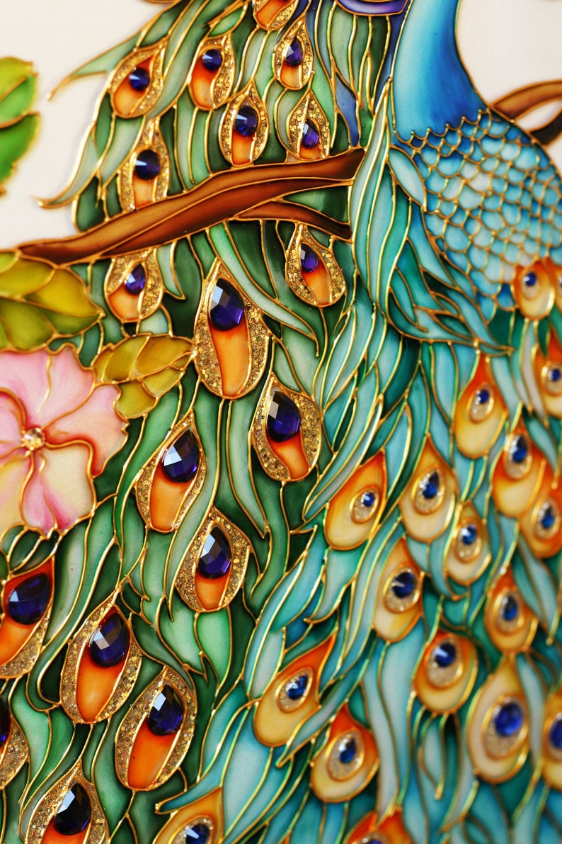 May include: Close-up of a vibrant peacock design. The artwork features a peacock's feathers in shades of teal, orange, and gold, with jewel-like accents. The design is set against a white background, with a pink flower and green leaves.