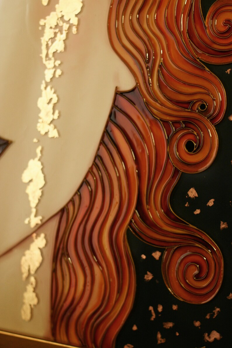 Puede incluir: Primer plano de una obra de arte en vitral que representa el cabello de una mujer. El cabello est&aacute; peinado en una serie de ondas y rizos, con un fondo oscuro y detalles dorados.