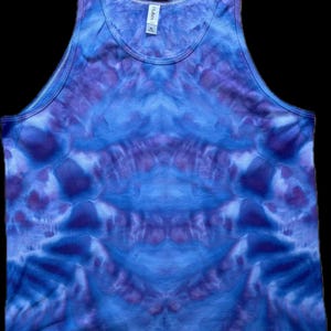 May include: A tie-dye tank top in shades of blue and purple. The tank top has a symmetrical pattern with a darker blue center and lighter blue edges.