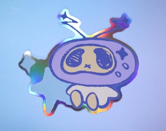 May include: A holographic sticker featuring a cartoon character with a purple head, large eyes, and a small mouth. The character is wearing a white hat with a star on it. The sticker is surrounded by a blue and green holographic background.
