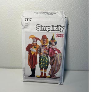 May include: A Simplicity 7117 sewing pattern envelope featuring illustrations of three clowns in colorful costumes. The left clown wears a red and yellow outfit, the center clown has a plaid shirt and polka dot pants, and the right clown wears striped pants.