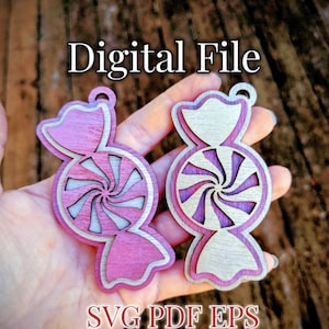 Può includere: Due ornamenti di bastoncino di zucchero in legno, uno rosa e uno bianco, con un design a spirale al centro. Gli ornamenti sono per il taglio laser e sono disponibili nei formati SVG, PDF ed EPS. File digitale SVG PDF EPS