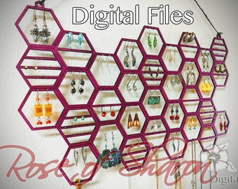May include: A pink hexagonal earring holder with 20 slots for earrings. The holder is made of wood and has a modern design. The text "Digital Files" is printed at the top of the image.