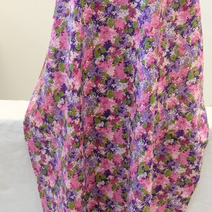 May include: Purple, pink and green floral fabric with a small-scale print. The fabric has a soft, flowing texture.