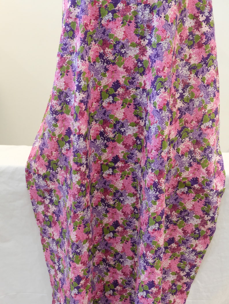 May include: Purple, pink and green floral fabric with a small-scale print. The fabric has a soft, flowing texture.