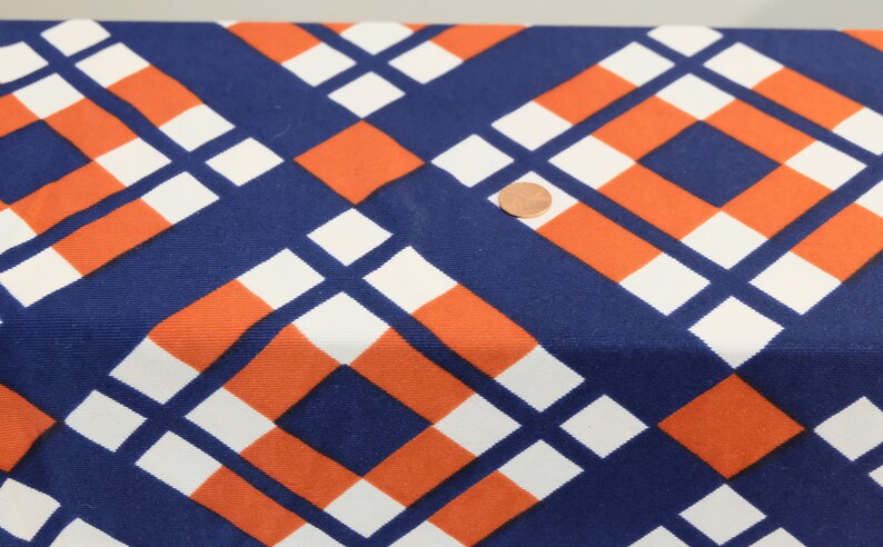 May include: Blue, white, and orange geometric fabric with a repeating pattern of squares and rectangles.