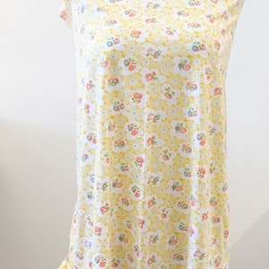 Puede incluir: Tela amarilla con fondo blanco y un peque&ntilde;o estampado floral. La tela est&aacute; drapeada sobre un maniqu&iacute; blanco.