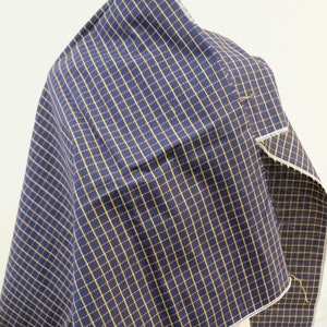 May include: A piece of navy blue fabric with a yellow and white checkered pattern.