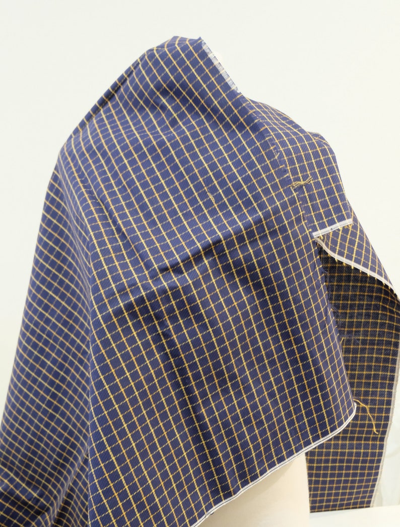 May include: A piece of navy blue fabric with a yellow and white checkered pattern.