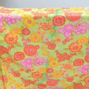 Puede incluir: Una tela verde con un patr&oacute;n floral con flores naranjas, amarillas y rosas. La tela tiene un aspecto vintage y ser&iacute;a ideal para proyectos de manualidades.