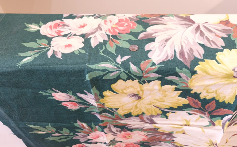 K&ouml;nnte beinhalten: Gr&uuml;ner Stoff mit einem floralen Druck mit rosa, wei&szlig;en und gelben Blumen. Der Stoff hat einen Vintage-Stil.