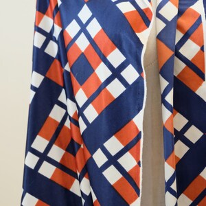 May include: A long-sleeved robe with a geometric pattern in shades of blue, white, and orange. The robe has a shawl collar and a tie closure.