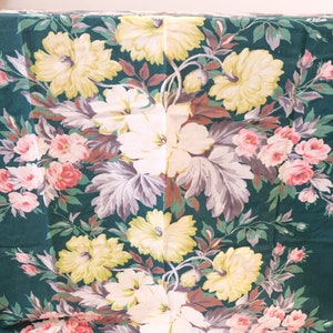 K&ouml;nnte beinhalten: Ein gr&uuml;ner Stoff mit einem floralen Muster mit rosa, wei&szlig;en und gelben Blumen. Der Stoff hat einen Vintage-Look und -Feel.