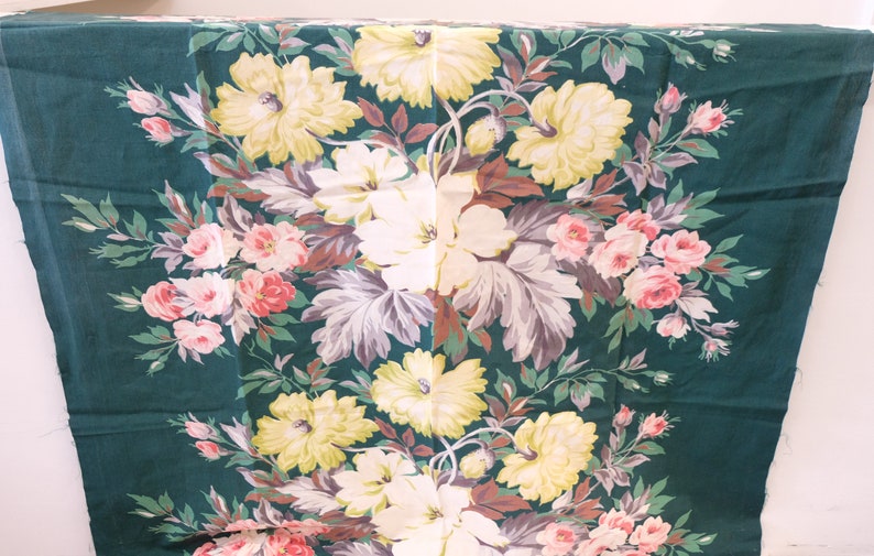 K&ouml;nnte beinhalten: Ein gr&uuml;ner Stoff mit einem floralen Muster mit rosa, wei&szlig;en und gelben Blumen. Der Stoff hat einen Vintage-Look und -Feel.