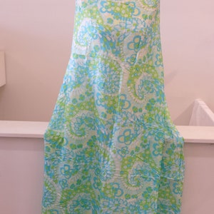 May include: A blue and green fabric with a floral pattern. The fabric is draped over a white surface.