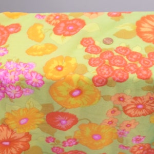 Puede incluir: Una tela verde con un patr&oacute;n floral con flores naranjas, amarillas y rosas. La tela tiene un aspecto vintage y ser&iacute;a ideal para proyectos de manualidades.