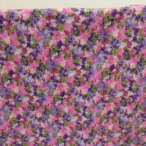 May include: A pink and purple floral fabric with a small-scale print. The fabric features a repeating pattern of pink, purple, and green flowers.