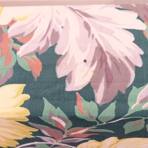 K&ouml;nnte beinhalten: Eine Nahaufnahme eines Stoffes mit einem Blumenmuster. Der Stoff ist dunkelgr&uuml;n mit rosa, wei&szlig;en und gelben Blumen. Die Blumen sind stilisiert und haben einen Vintage-Look.