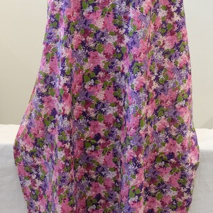May include: Purple and pink floral fabric with a small-scale print. The fabric has a soft, flowing texture and is ideal for crafting projects.