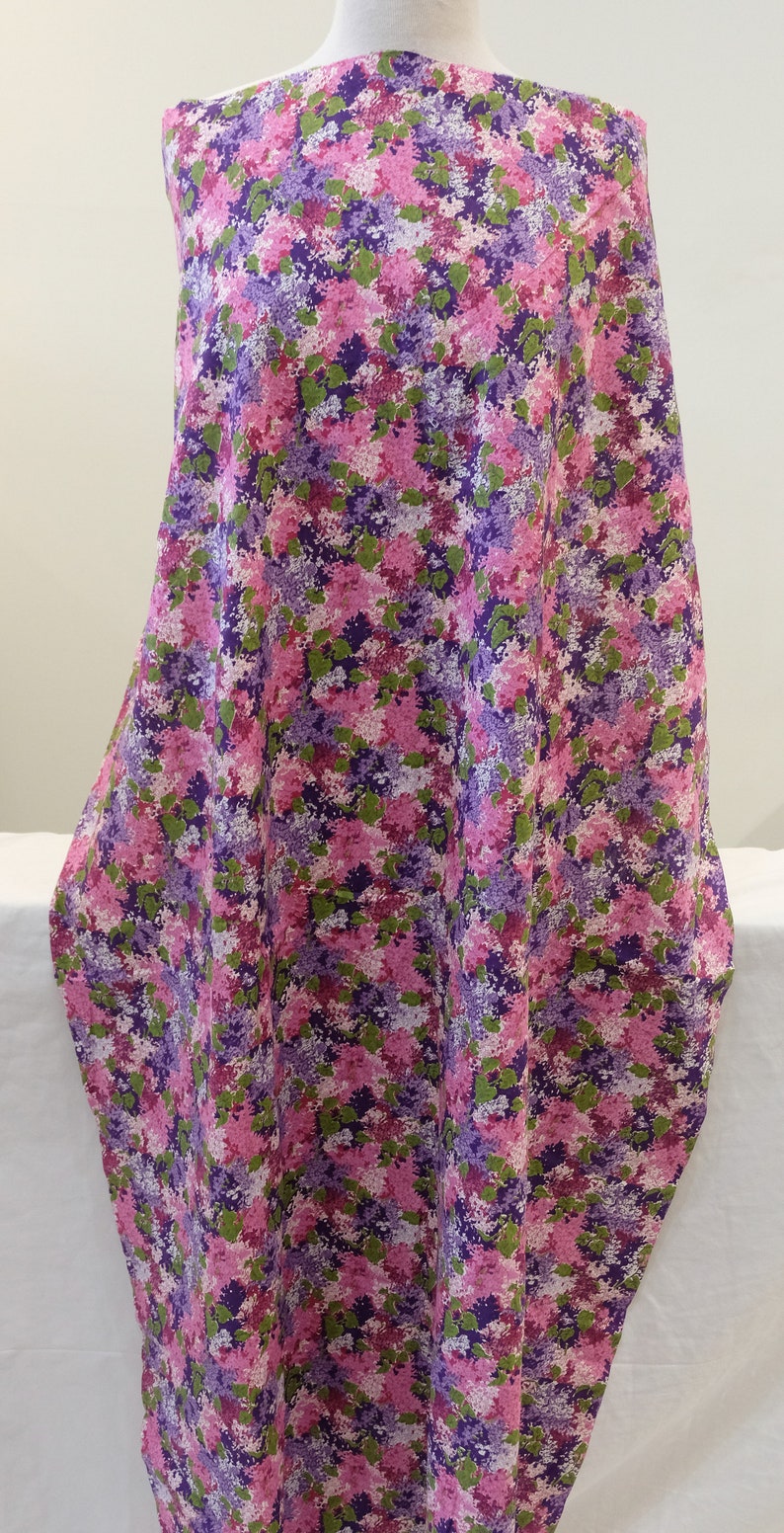 May include: Purple and pink floral fabric with a small-scale print. The fabric has a soft, flowing texture and is ideal for crafting projects.