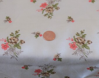 May include: White fabric with a floral pattern featuring small pink and brown flowers. The fabric is textured and has a subtle sheen.