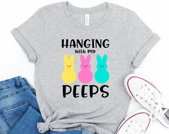 Könnte beinhalten: Ein graues T-Shirt mit dem Text "HANGING WITH MY PEEPS" und drei bunten Peeps-Marshmallow-Hasen.