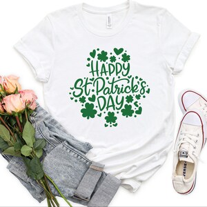 May include: White t-shirt with green shamrock design and the text "Happy St. Patrick's Day".