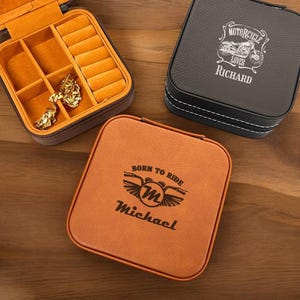 May include: Two brown leatherette jewelry boxes with engraved designs. One box has the text "Born to Ride" and a motorcycle graphic with the initial "M" and the name "Michael". The other box has the text "Motorcycle Lover" and a motorcycle graphic with the name "Richard".