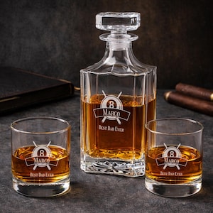 May include: A clear glass decanter and two matching whiskey glasses filled with amber liquid. Each piece features an etched design with the number 8, the name MARCO, and the text BEST DAD EVER, accompanied by a graphic of two crossed pool cues.