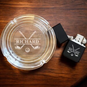 May include: A personalized glass ashtray and a black lighter with a golf club and ball design. Both items are engraved with the name "RICHARD".