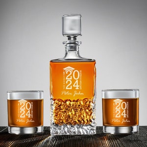 May include: A set of three clear glass decanters with a graduation theme. The decanters are decorated with the text "Class of 2024 Lincoln College" and the name "Peter John".