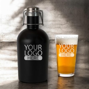 May include: A black stainless steel growler with a silver lid and handle. The growler has the text "YOUR LOGO HERE" engraved on the front. A glass of beer with a white head is next to the growler.