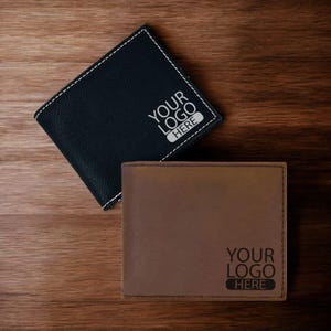 May include: Two leather wallets, one black and one brown, with the text "YOUR LOGO HERE" engraved on each.