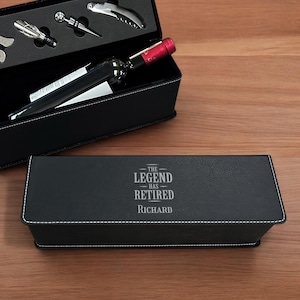 May include: Black leatherette gift box with a wine bottle and accessories inside. The box is engraved with the text "The Legend Has Retired Richard".