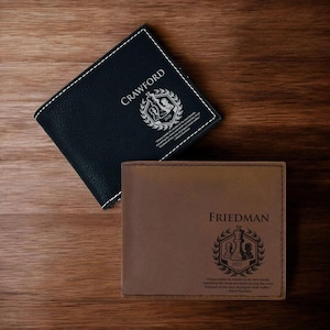 May include: Two leather wallets with a chess theme. The top wallet is black with the name "Crawford" and the year "2023" engraved on it. The bottom wallet is brown with the name "Friedman" and the year "2023" engraved on it. Both wallets have a quote about chess engraved on them.