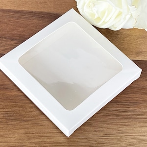 May include: White square box with a clear window, perfect for displaying small items.
