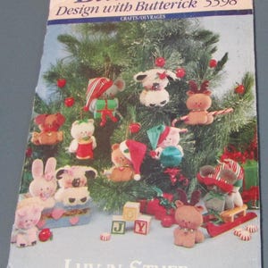 May include: A Butterick 5598 sewing pattern envelope titled Luv 'n Stuff featuring illustrations of various small plush animal ornaments including mice, bears, and rabbits wearing holiday hats and scarves, displayed around a green Christmas tree.