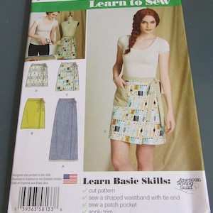 May include: Simplicity 8133 Learn to Sew pattern envelope featuring illustrations and photographs of wrap skirts in various lengths and prints. The cover displays the text Learn to Sew, Learn Basic Skills, and American Sewing Guild.