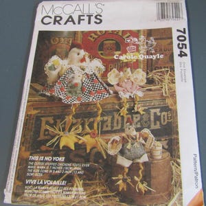 May include: McCall's Crafts sewing pattern 7054 for stuffed chickens by Carole Quayle. The envelope features illustrations of three fabric chickens in various outfits. Text includes 'This is no yoke' and 'Mama is 7 inches (18cm) high'.