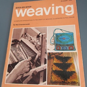 May include: A softcover book titled Step-By-Step Weaving by Nell Znamierowski with an orange cover. The cover features three photographs: a black and white image of a loom, a blue woven bag, and a textured black and yellow rug.
