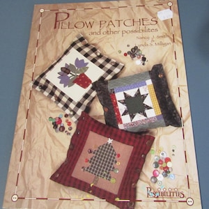 May include: A craft pattern titled "Pillow Patches and other possibilities" featuring three decorative pillows. One pillow has a flower pot design, another a star, and the third a Christmas tree. Various buttons are scattered around the pillows.