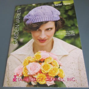 May include: A knitting pattern booklet titled Garden Variety by Tahki Yarns, featuring a light purple knit beret with a textured pattern. The cover displays a bouquet of pink and yellow roses and the text Cotton Classic, Cotton Classic Lite 4th Edition.