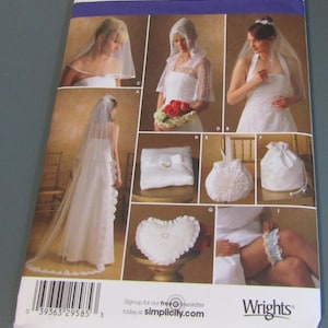 May include: A Simplicity 4216 sewing pattern envelope featuring illustrations of bridal accessories including various veils, a ring pillow, a heart-shaped cushion, a drawstring pouch, and a garter. The package displays the brand name and barcode.