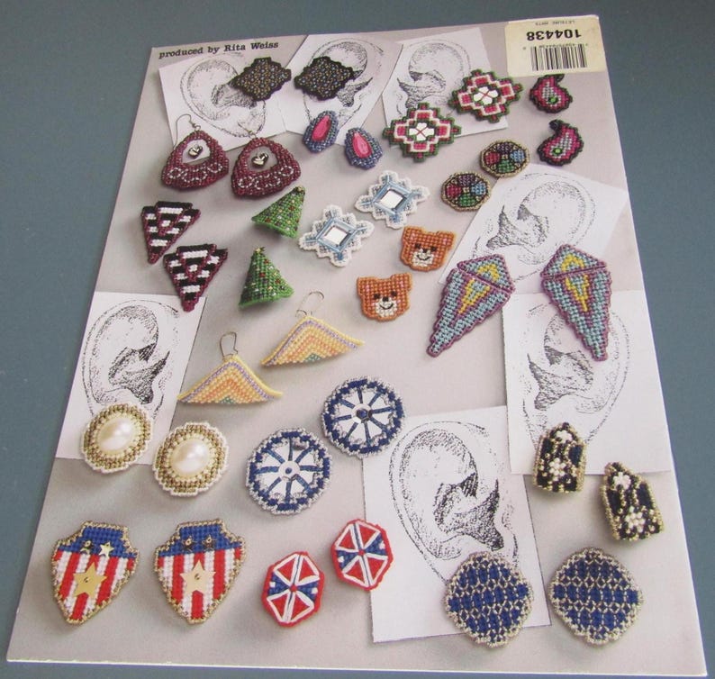 May include: A selection of handmade earrings in diverse shapes and designs. The earrings showcase a variety of colours, including red, blue, green, and white. Some earrings have pearl accents, while others feature geometric patterns. The earrings are displayed on a printed background.