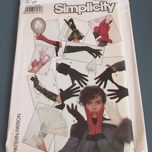May include: A Simplicity 8774 sewing pattern envelope for The Accessory Club. The white paper cover features multiple photographs of various gloves, including red, black, and white styles, some with lace, bows, or fur trim, and a white lace fan.
