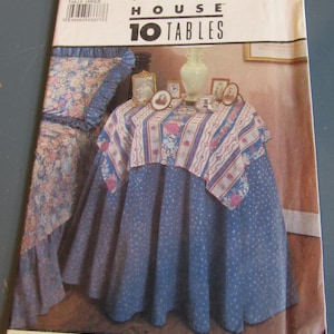 May include: A Simplicity House pattern for 10 tables. The pattern cover features a table with a blue tablecloth with white polka dots and a floral patterned top layer. The cover also shows a pillow with a floral pattern.
