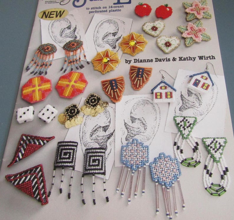 May include: A selection of handcrafted earrings and small crafts, including dice, hearts, and geometric shapes. The earrings showcase diverse designs, like houses, flowers, and abstract patterns. The colour scheme incorporates red, yellow, blue, and white.