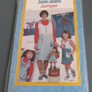 May include: A sewing pattern envelope titled Junk-Jeans Jumper, JUM-1012, copyright 1999. The cover features photographs of a jumper in various styles, including views A, B, C, and D, modeled by individuals and a doll, showcasing denim fabric.