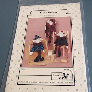 May include: A package featuring a craft pattern titled "Make Believe" with three elf dolls. The elves have bead-filled bodies and are shown in various poses with wooden toy accessories. The Jenny Wren Ltd. logo is visible.